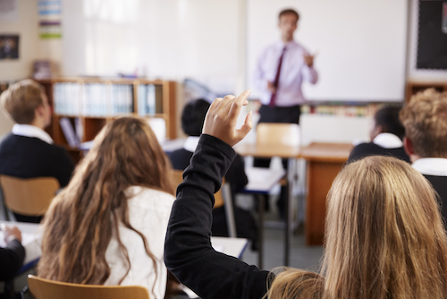 female student raising hand to ask question in PTLD23C