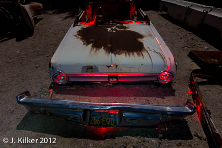 Rear view of a 1964 Ford Falcon in the automobile graveyard at Zzyzx. If cars have faces, this detached bumper reminds me of one with a handlebar moustache. IMG_9995